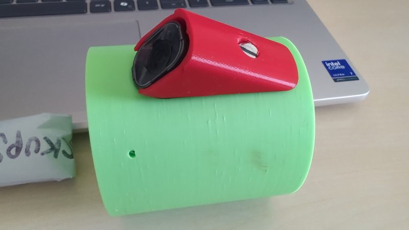 The red camera fairing mounted on the green housing